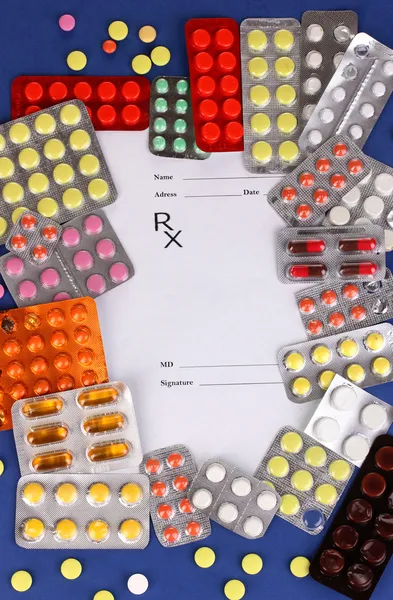 Kapsle a pilulky, které jsou baleny v blistrech s předpis lékárníka na modré — Stock fotografie