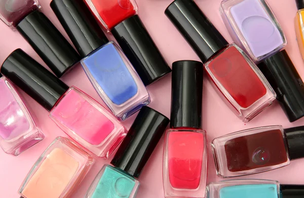 Group of bright nail polishes, on pink background — Stock Photo, Image