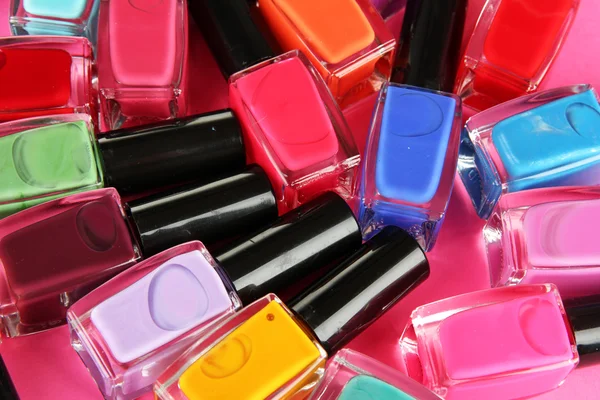 Group of bright nail polishes, on pink background — Stock Photo, Image