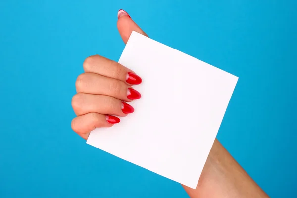 Mano de la mujer sosteniendo la tarjeta en blanco sobre fondo de color — Foto de Stock
