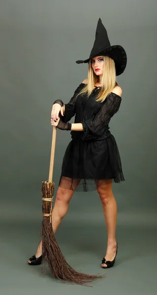 Halloween witch with broom on gray background — Stock Photo, Image