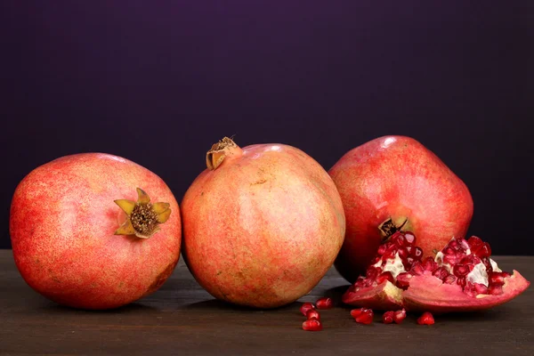Ripe pomegranates on purple background — Stock Photo, Image