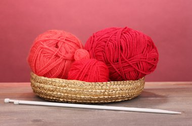 sepeti ahşap masa üzerinde kırmızı zemin üzerine kırmızı örgüler iplikler