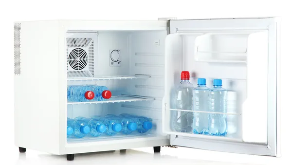Mini-Kühlschrank voller Mineralwasser isoliert auf weiß — Stockfoto