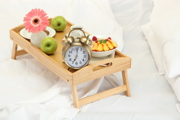 Houten dienblad met licht ontbijt op bed — Stockfoto