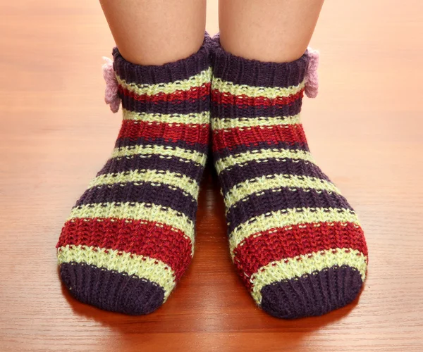 Beine weiblich in gestreiften Socken auf Laminatboden — Stockfoto