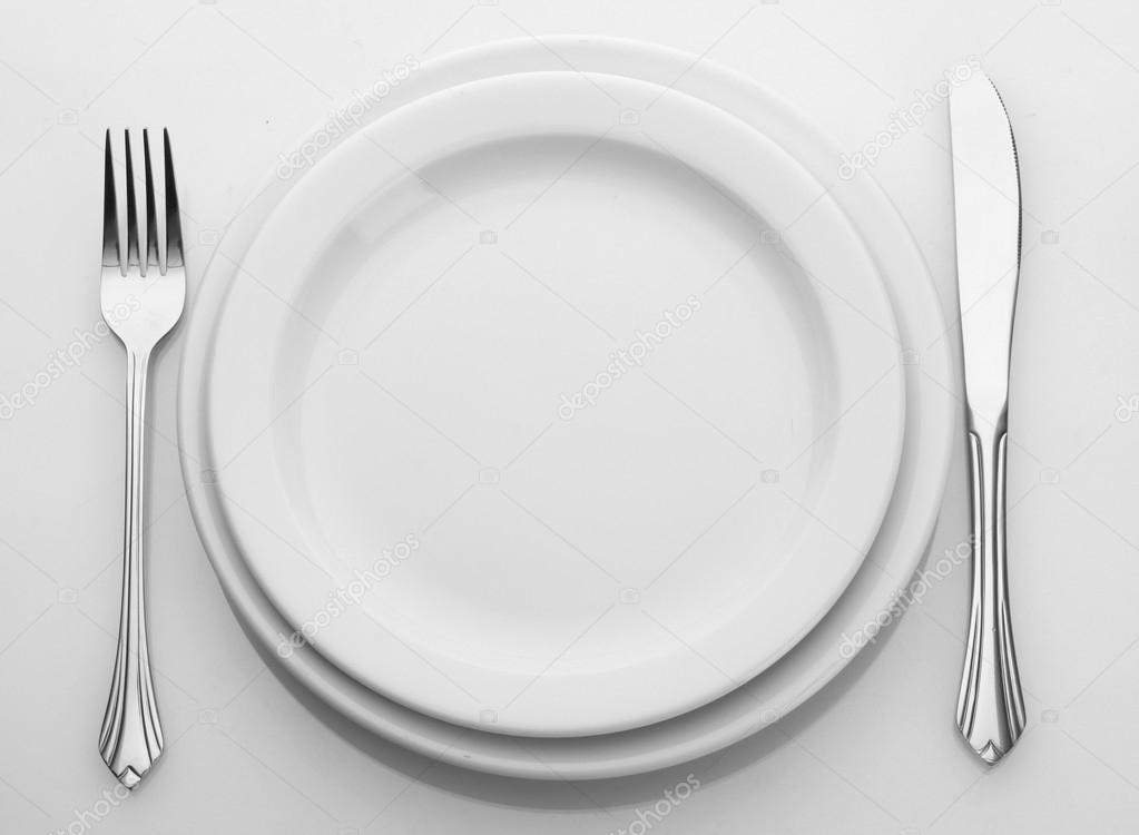 White empty plate with fork and knife isolated on white