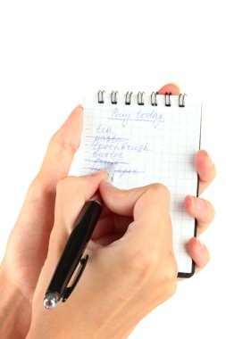 Kadının elinde alışveriş listesi olan bir defter var.