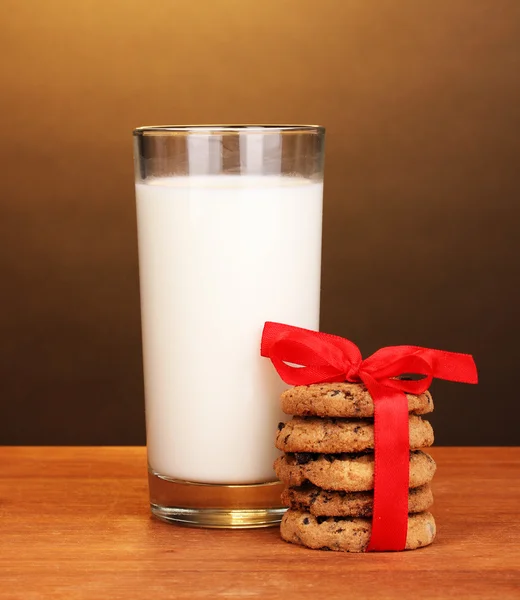 杯牛奶和棕色背景上的木桌上的饼干 — 图库照片