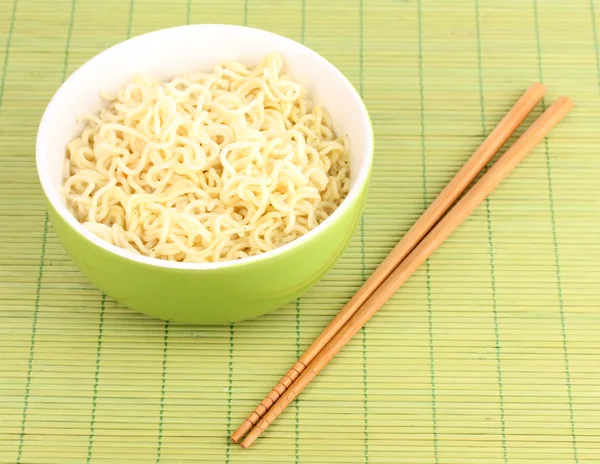 Macarrão asiático em tigela no tapete de bambu — Fotografia de Stock