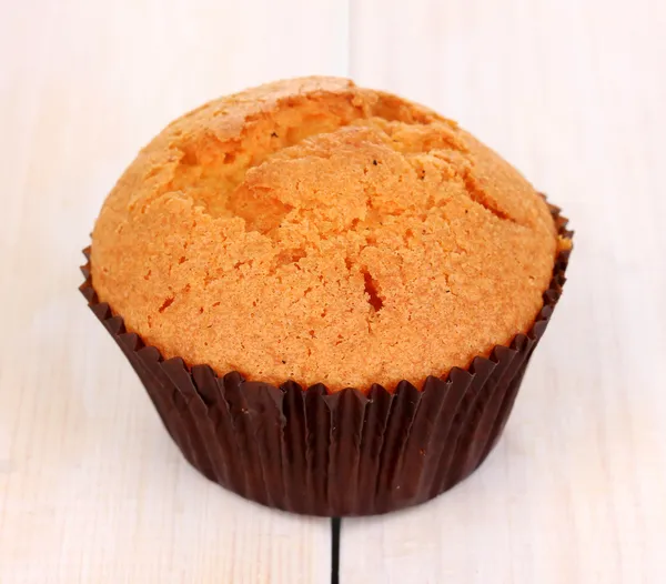 Čerstvý muffin na dřevěné pozadí — Stock fotografie