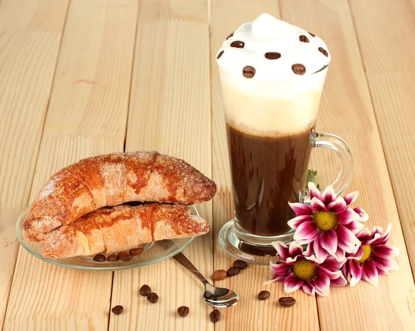 Bicchiere di caffè fresco cocktail e piattino con bagel su sfondo di legno — Foto Stock