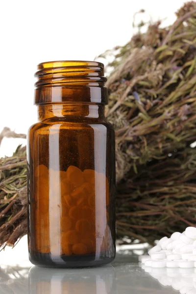 Garrafa de medicamentos com ervas no fundo branco. conceito de homeopatia — Fotografia de Stock