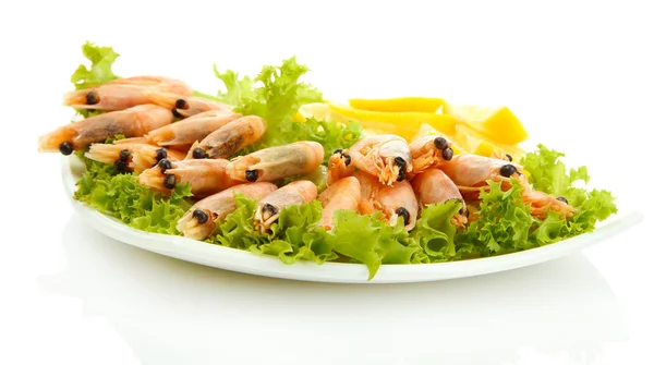 Crevettes bouillies avec des feuilles de citron et de laitue sur l'assiette, isolées sur blanc — Photo