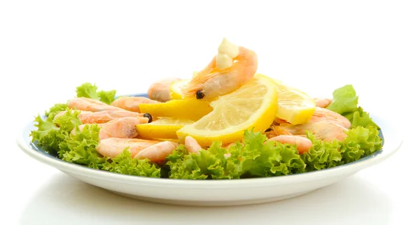 Crevettes bouillies avec des feuilles de citron et de laitue sur l'assiette, isolées sur blanc — Photo