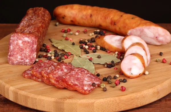 Tasty sausages on chopping board on browm background — Stock Photo, Image