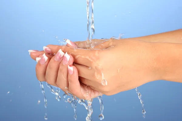 Πλύσιμο των χεριών της γυναίκας σε κοντινό πλάνο μπλε φόντο — Φωτογραφία Αρχείου
