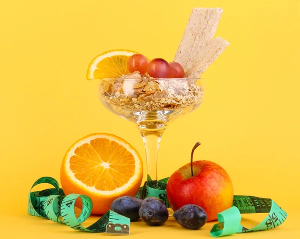 Tüdő müzli, vázában, desszertek, gyümölcsök sárga háttér — Stock Fotó