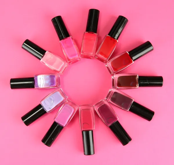 Grupp av ljusa nagellack, på rosa bakgrund — Stockfoto