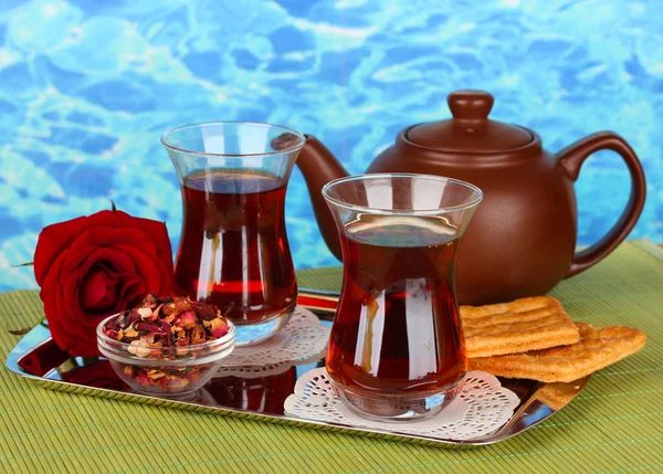 Glas türkischer Tee und Wasserkocher auf farbigem Hintergrund — Stockfoto