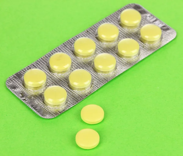 Pillen verpakt in blister op groene achtergrond — Stockfoto