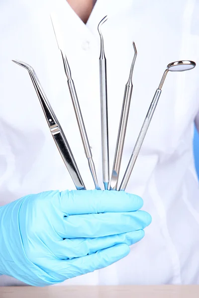 Um dentista mãos em luvas médicas azuis com ferramentas dentárias — Fotografia de Stock