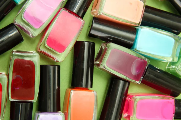 Group of bright nail polishes, on green background — Stock Photo, Image