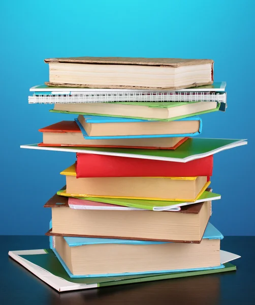 Stack of interesting books and magazines on wooden table on blue background — Zdjęcie stockowe