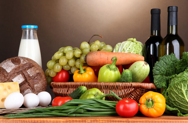 Composition with vegetables in wicker basket on brown background