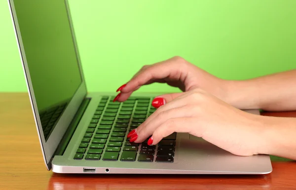 Detalhe de mãos femininas usando o computador no fundo de cor — Fotografia de Stock