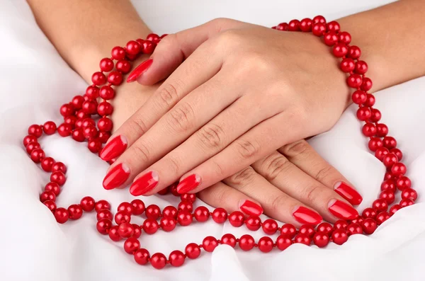 Mãos femininas segurando contas no fundo de cor — Fotografia de Stock