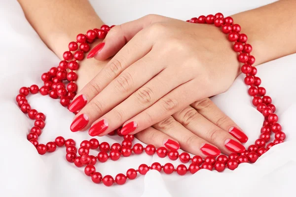 Mãos femininas segurando contas no fundo de cor — Fotografia de Stock