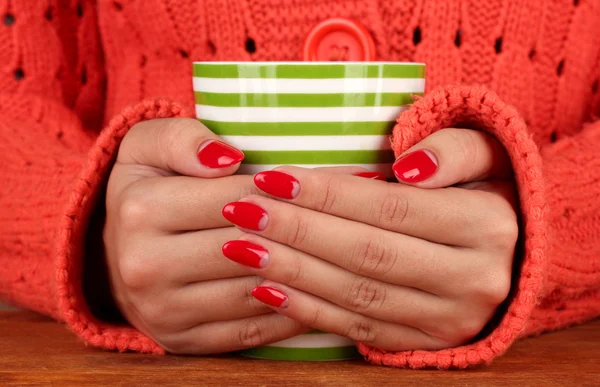 Hände halten Becher mit Heißgetränk, Nahaufnahme — Stockfoto