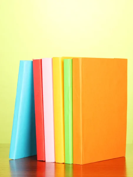 Empilement de livres multicolores sur fond vert — Photo