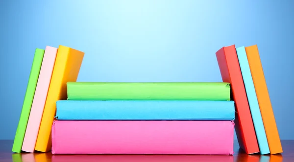 Stack of multicolor books on blue background — Stock Photo, Image