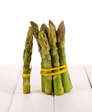 beyaz zemin üzerine ahşap masa üzerinde yararlı kuşkonmaz