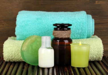 Ahşap ahşap arka plan masaya üzerinde dinlenmek için aksesuarlar ile aromatik yağlar ile şişe