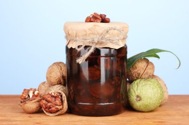 Ceviz ahşap masa mavi zemin üzerine üzerine reçel kavanoz