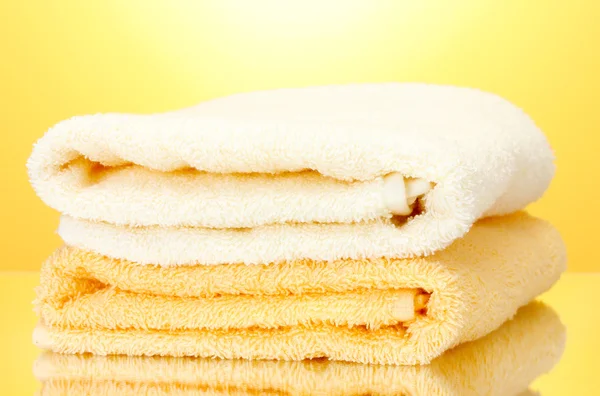 Colorful towels on yellow background — Stock Photo, Image