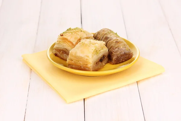 Sweet baklava on plate on wooden background — Stock Photo, Image