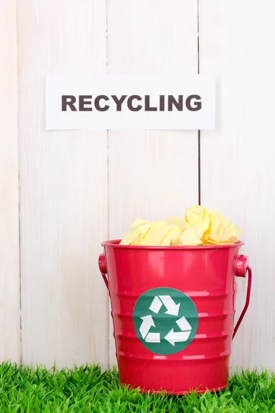 Papelera de reciclaje en hierba verde cerca de valla de madera — Foto de Stock