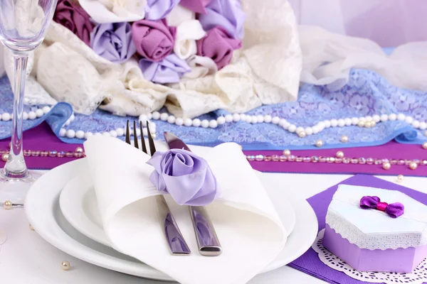 Servir fabulosa mesa de boda en color púrpura sobre fondo de tela blanca — Foto de Stock