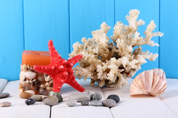 Decor of seashells on wooden table on blue wooden background — Stock Photo, Image