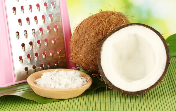 Coconuts wirh pink grater on green bamboo mat close-up — Stock Photo, Image