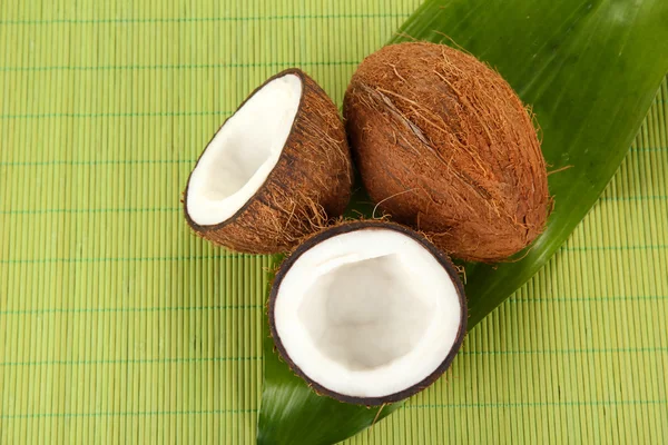 Coconuts on a green wicker mst close-up — Stock Photo, Image