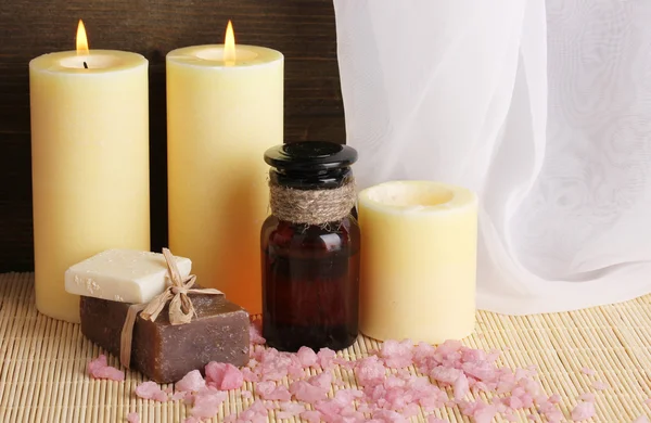 Botella con aceites aromáticos con accesorios para la relajación de cerca en la mesa de madera sobre fondo de madera — Foto de Stock