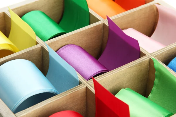 Bright silk ribbons in wooden box, close up — Stock Photo, Image