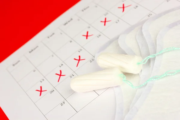 Calendario de menstruación con toallas sanitarias y tampones, primer plano —  Fotos de Stock