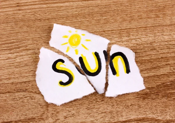 단어와 찢어진된 종이 태양 나무 테이블에 근접 — 스톡 사진