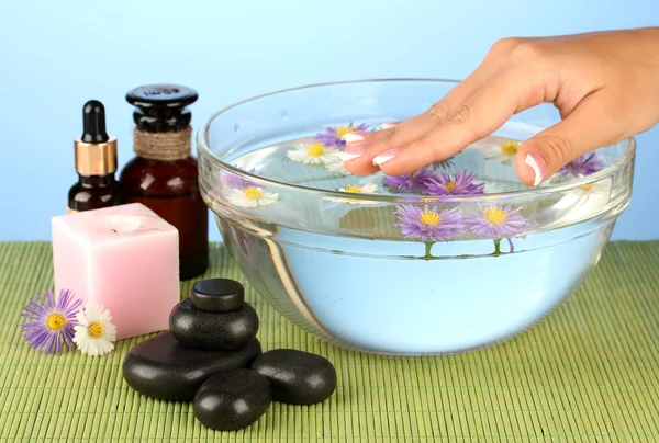 Tratamentos de spa para as mãos femininas, no fundo azul — Fotografia de Stock